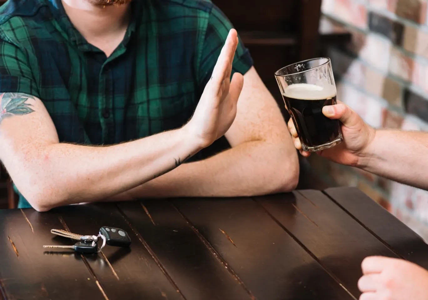 Wszywka alkoholowa Esperal / Disulfiram Konin: dłoń odmawiająca kufla piwa przy stole